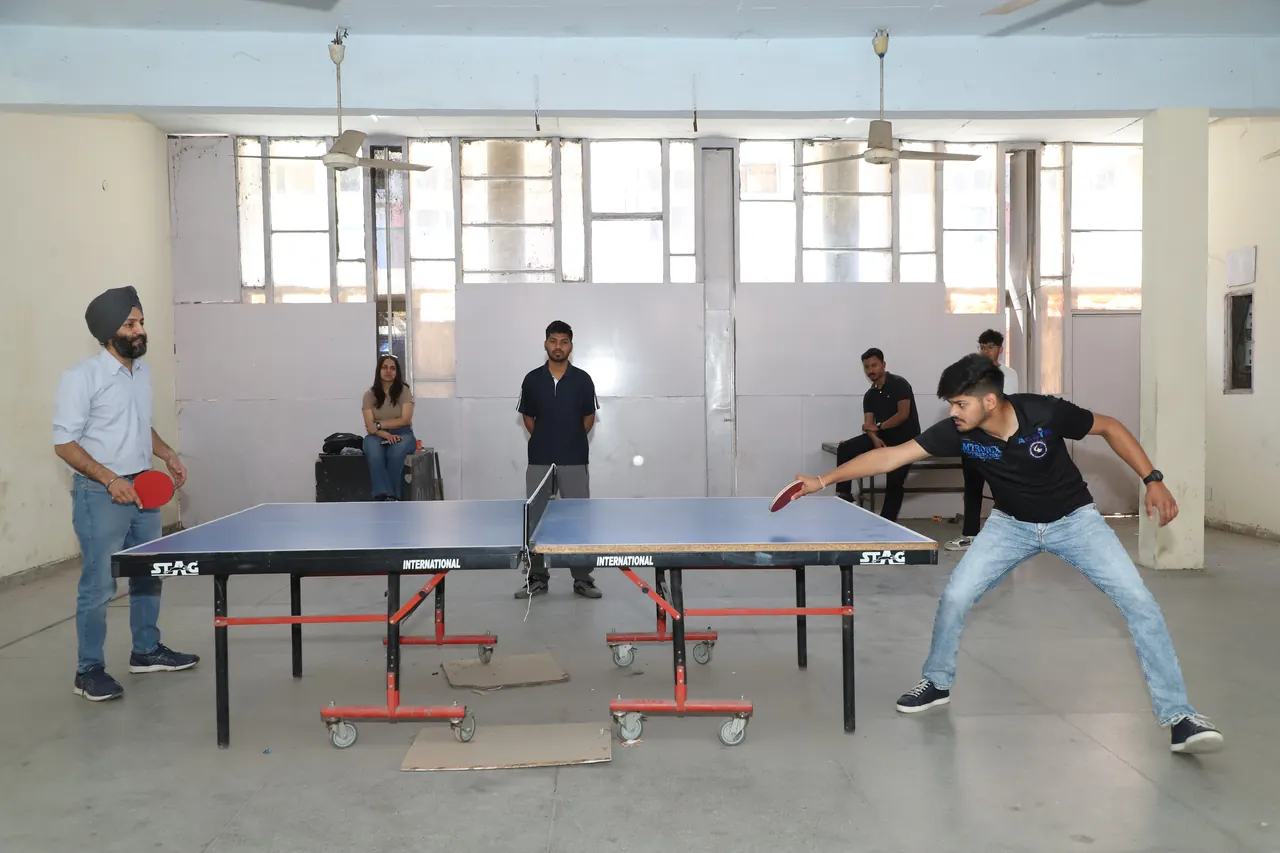 A table tennis player stretches for a forehand at the table